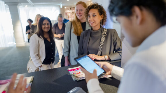 Een deelnemer checkt in bij een balie voor het event.