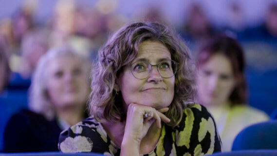 Een deelnemer luistert aandachtig naar een lezing