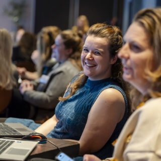 Twee deelnemers zitten in de masterclass ruimte met een laptop
