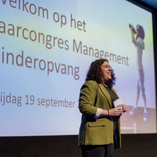Dagvoorzitter staat op het podium