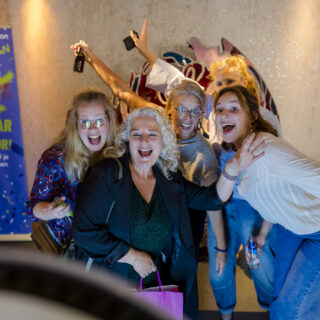 Deelnemers nemen een foto met elkaar bij de photobooth